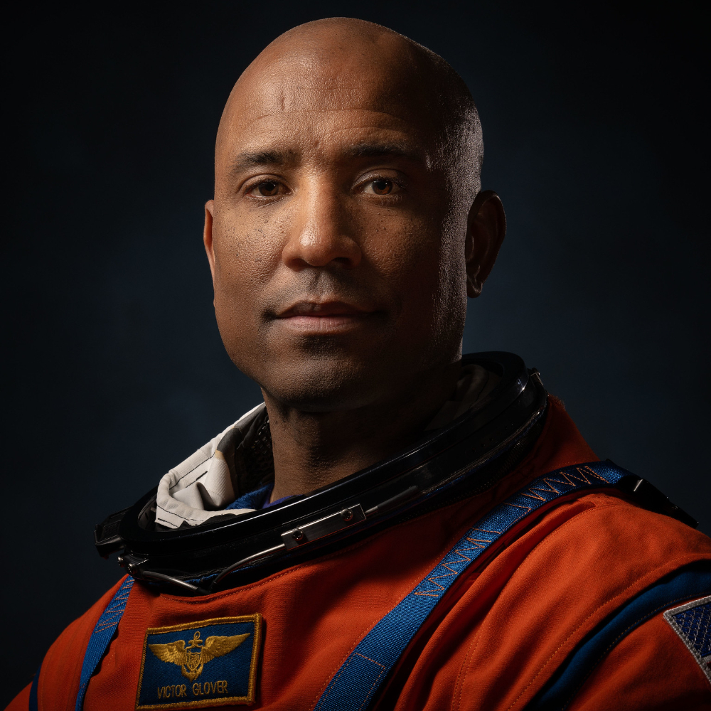 Portrait of Victor Glover, standing in his astronaut suit