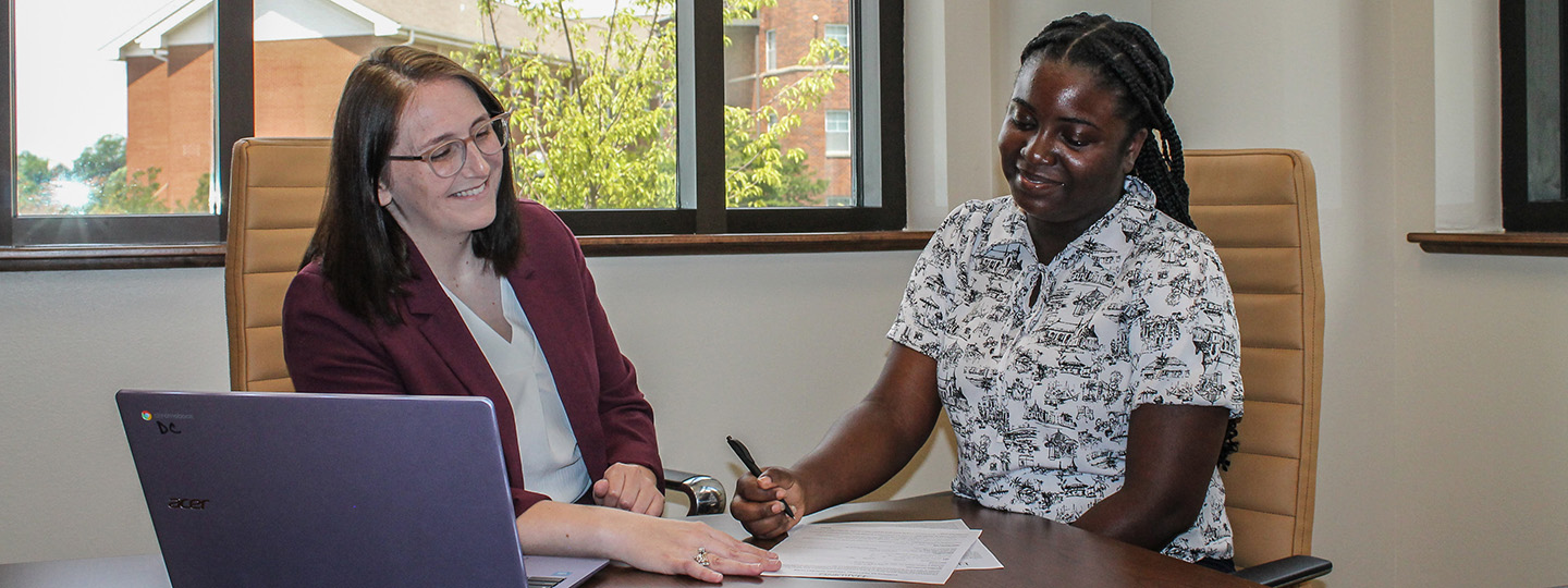 A teacher assisting a student with paperwork