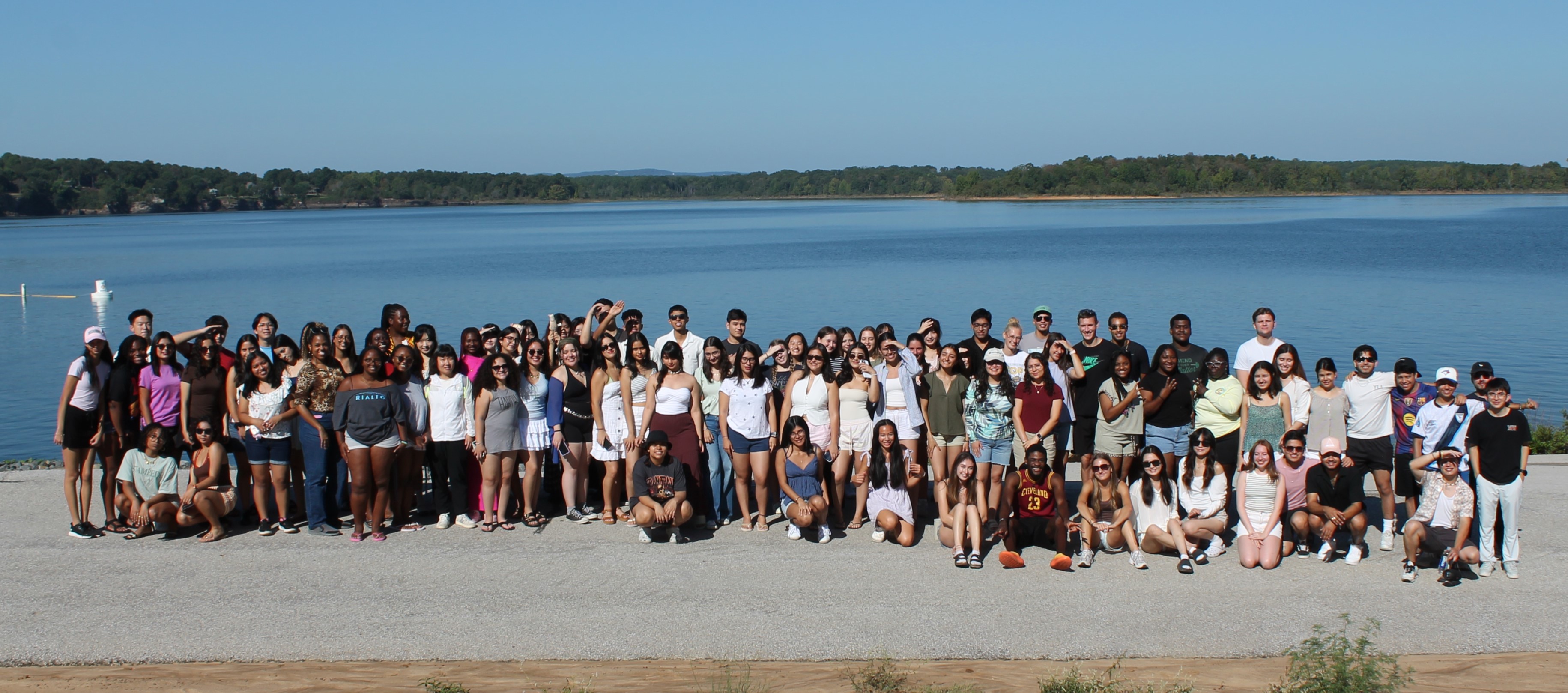 Students standing in a group by the lake