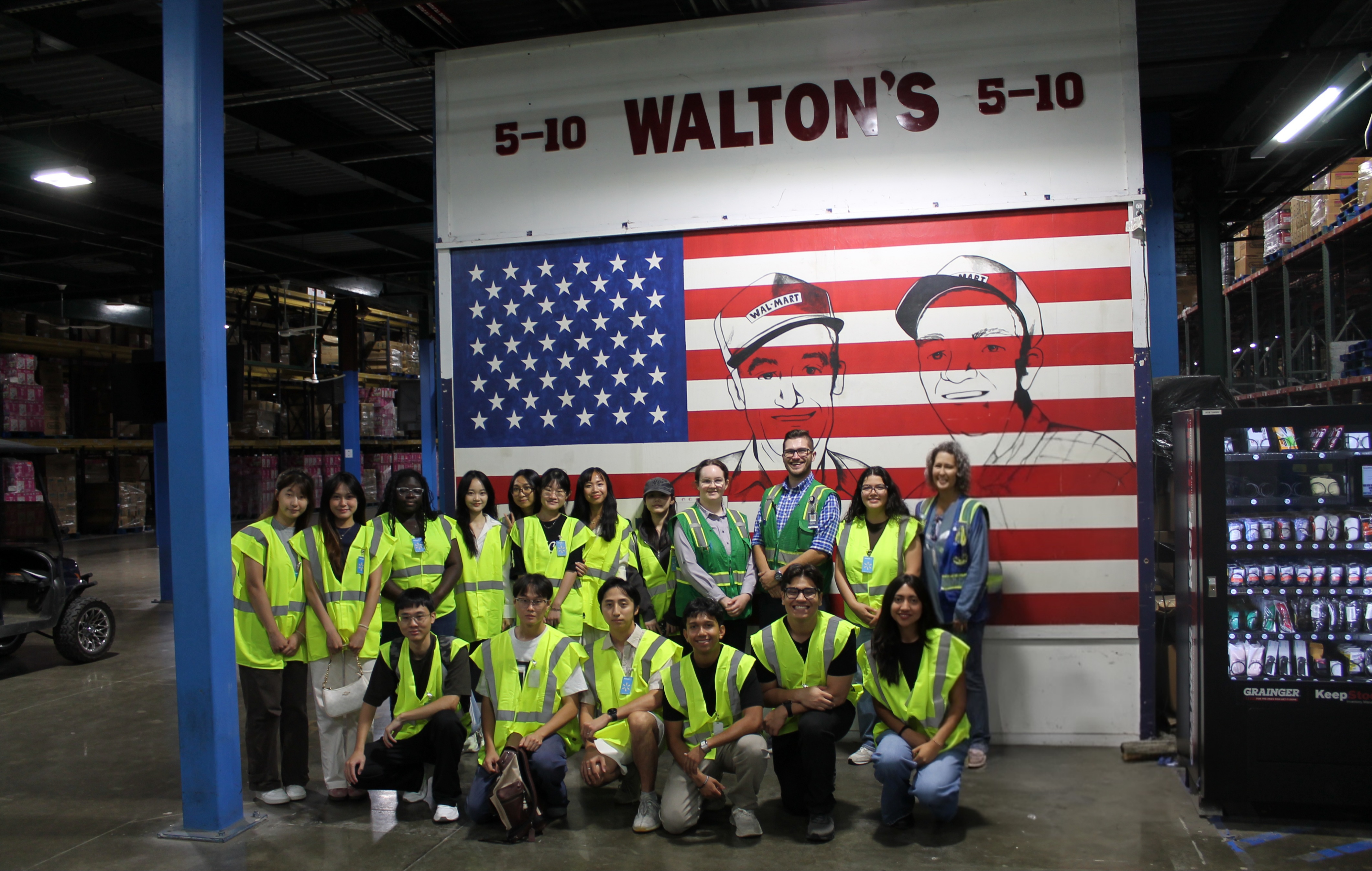People standing in from of american flag wall