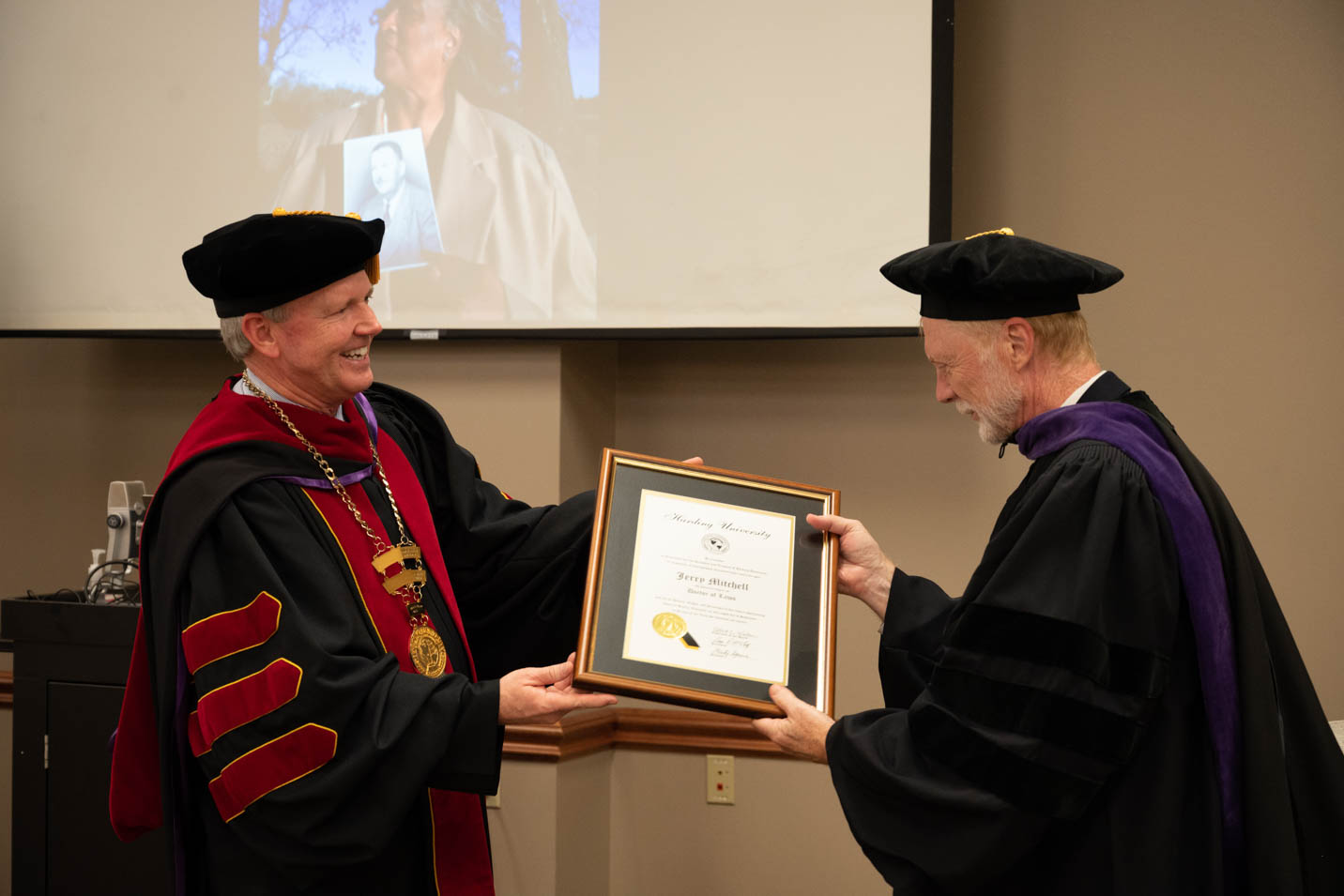 This is a photo of Jerry Mitchell at Harding University, receiving his honorary doctorate from Dr. Bruce McLarty.