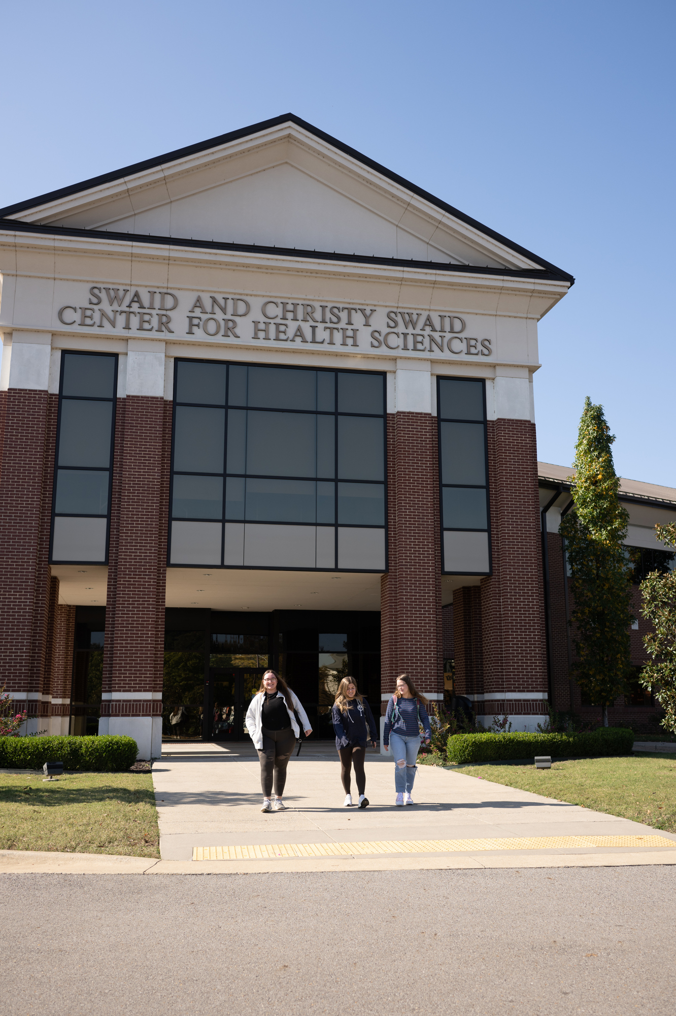 Three students walking out of the Swaid and Christy Swaid Center for Health Sciences