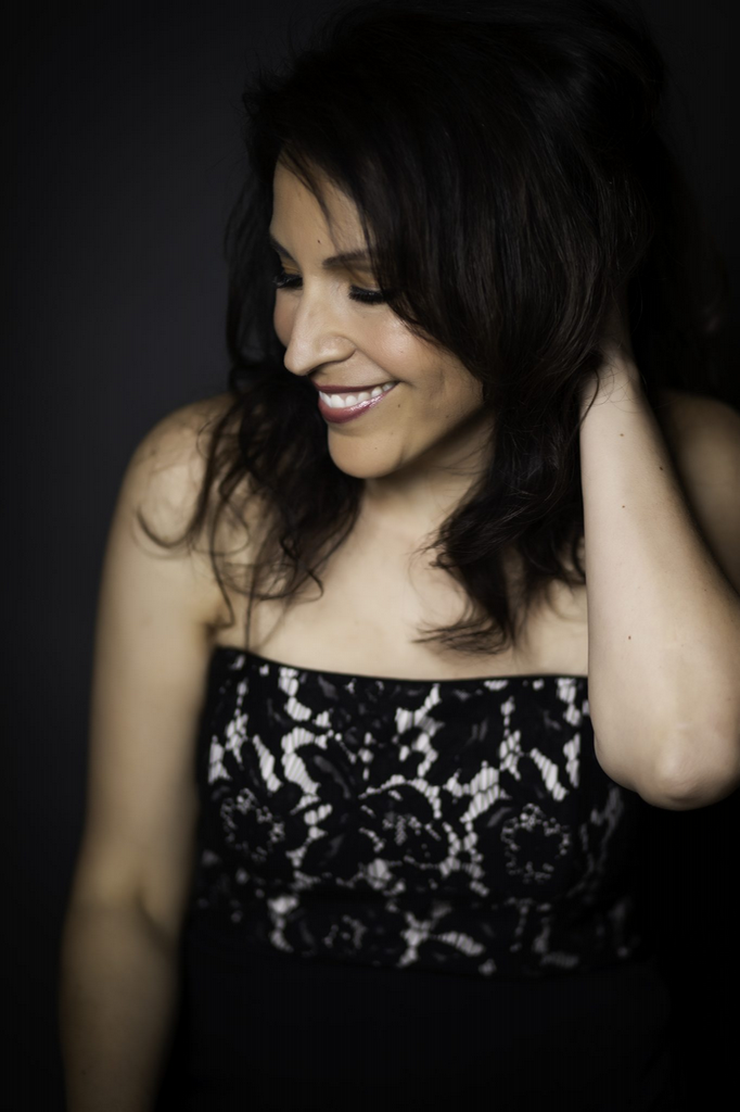 Rosanna Eckert, a white woman with black hair in a white and black lace dress, posing for a photograph