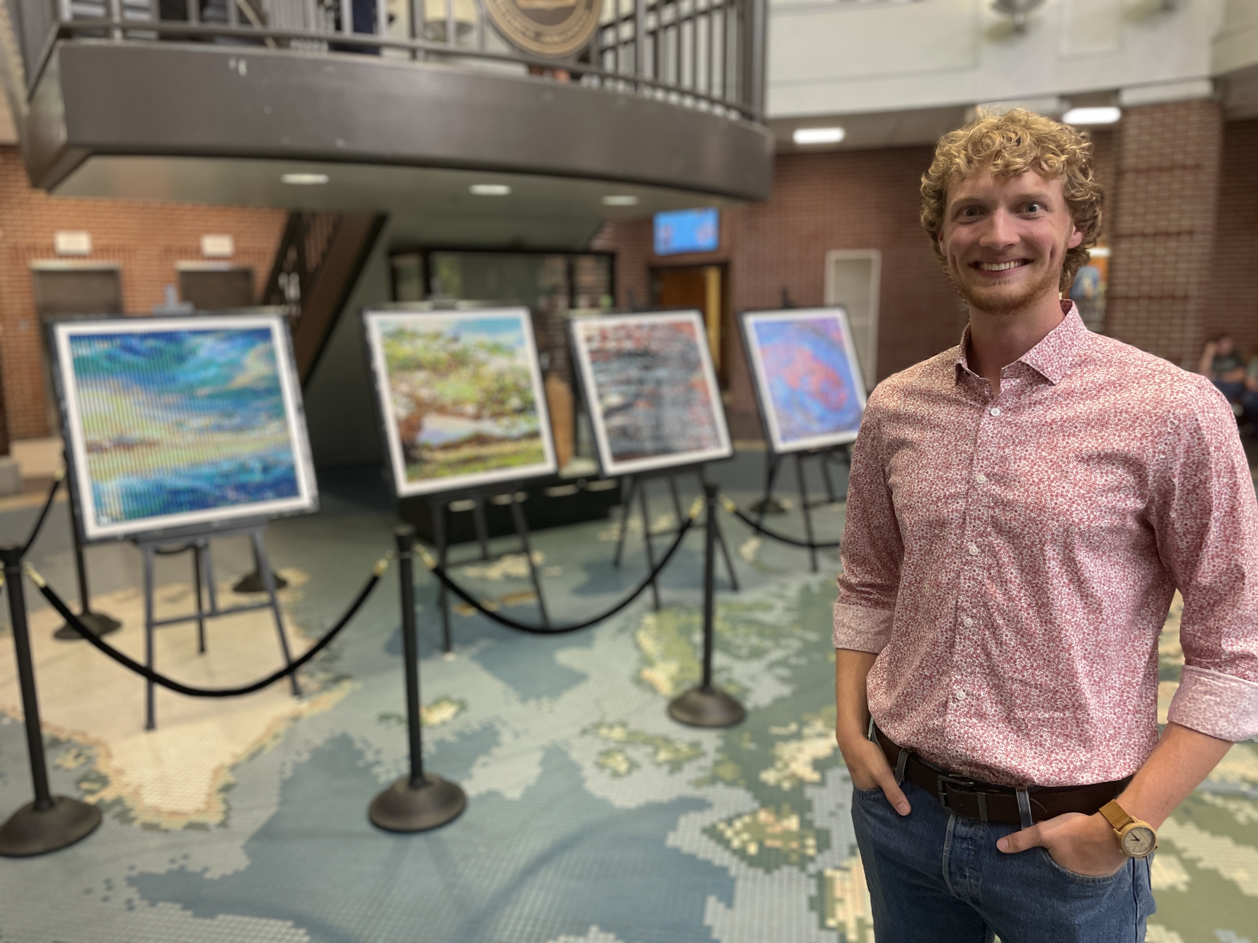 Cooper standing in front of this 4 framed pieces of lego art