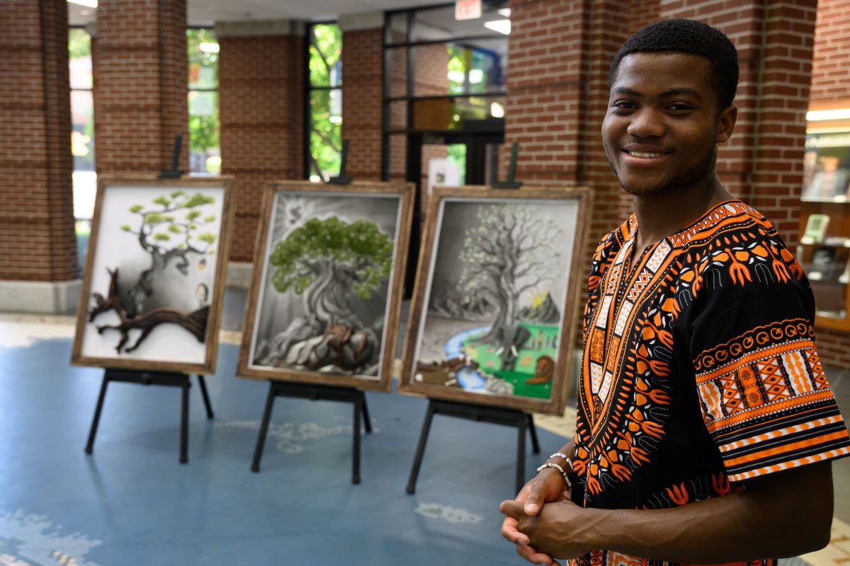 Four vibrant paintings of animal-headed figures in Harding’s McInteer Bible Building, a bright, windowed space.