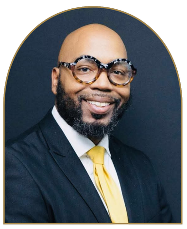 Dr. Tradanius Beard smiling in a suit.