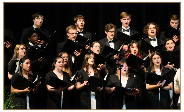 Men and women singing on risers with books