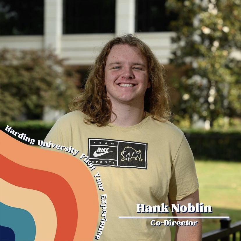 Stampede Co-Director Hank Noblin smiles in front of a colorful background