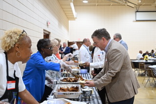 People serving food at the luncheon.